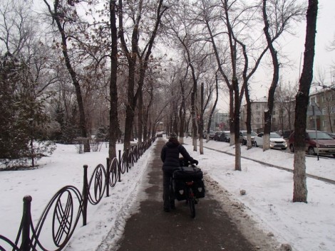 Pushing bike through streets of Almaty.
